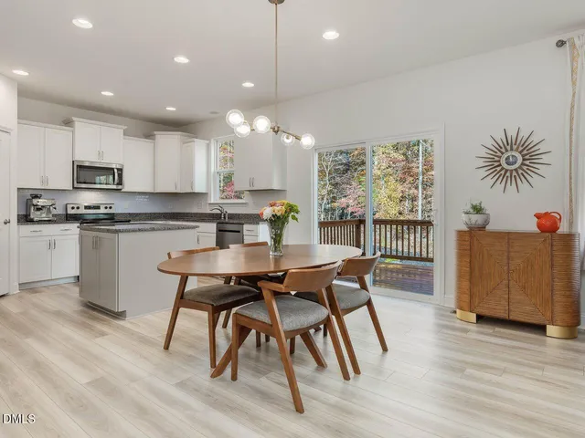 a kitchen with stainless steel appliances granite countertop a sink dishwasher a refrigerator and a stove with wooden floor