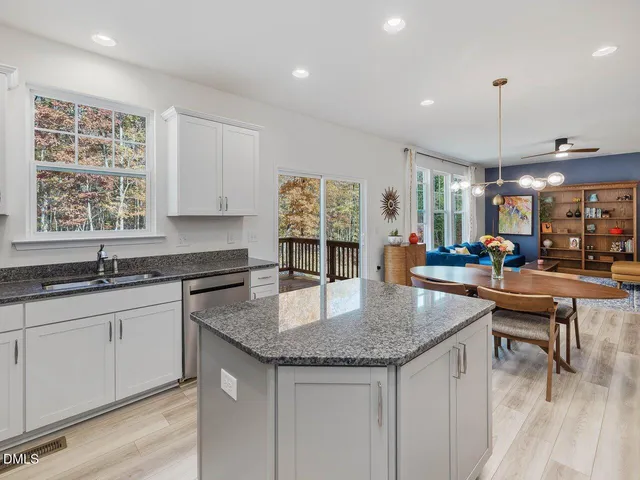 a kitchen with granite countertop a refrigerator and a stove top oven