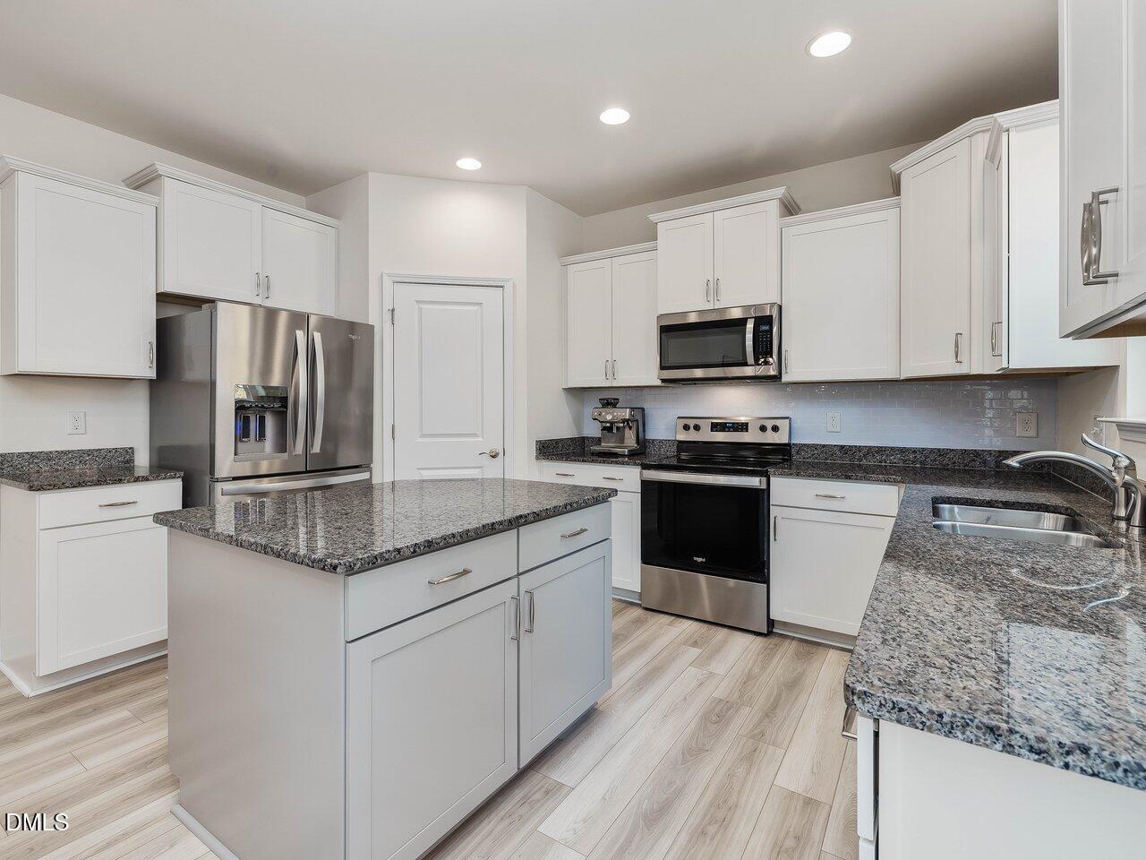 718 Heartpine Drive Mebane, NC 27302 - Photo 14 of 62 a kitchen with granite countertop a refrigerator and a stove top oven