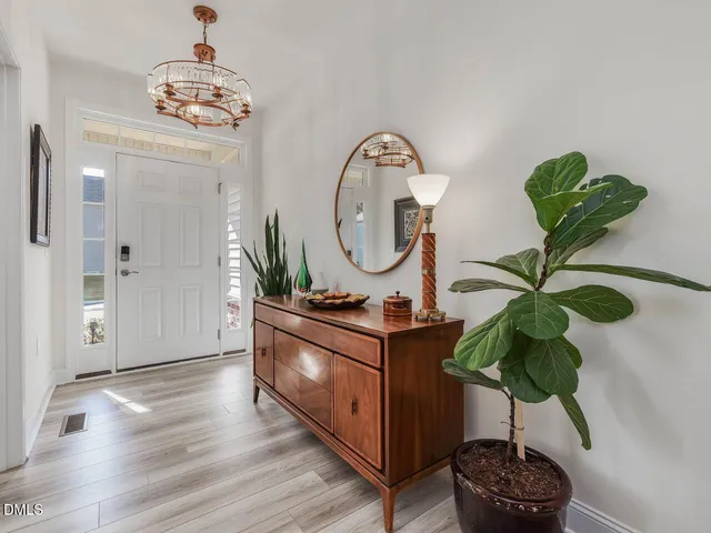 a living room with furniture chandelier and a potted plant