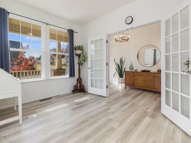 a living room with wooden floor and a large window