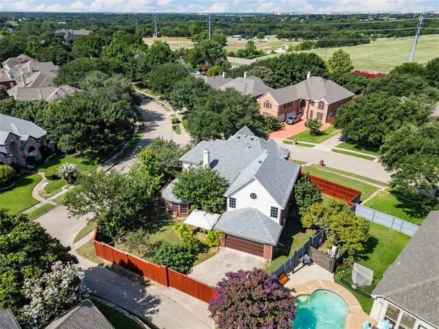 an aerial view of a house with a garden and lake view