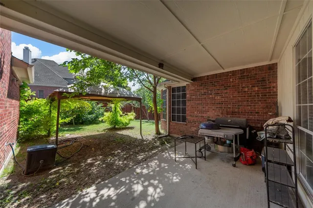 a view of a patio with table and chairs next to a yard