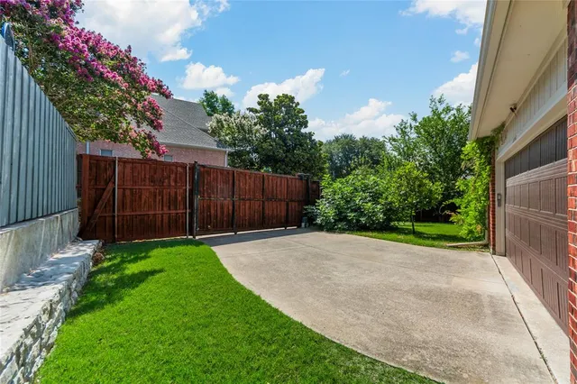 a view of a backyard with potted plants and wooden fence