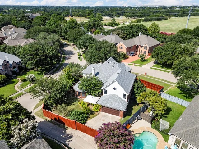 an aerial view of a house with a garden and lake view