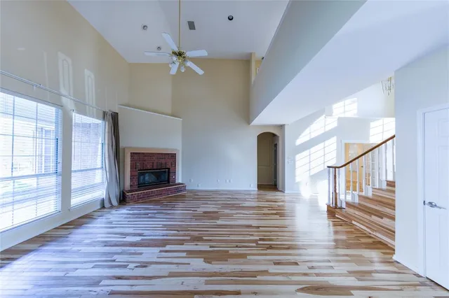a view of a livingroom with wooden floor a fireplace and windows
