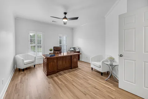 a view of a hallway with a bedroom and wooden floor