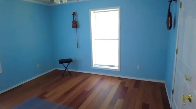 a view of a room with wooden floor and a window