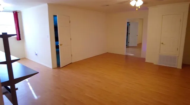 a view of an empty room with wooden floor