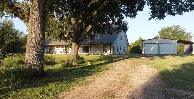a view of a house with a yard garage and tree s