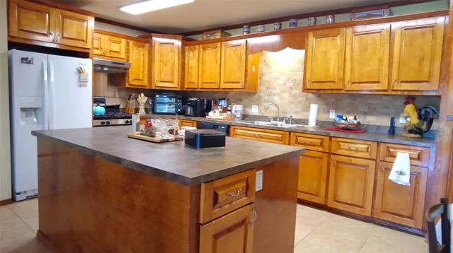 a kitchen with stainless steel appliances a sink a stove and a refrigerator