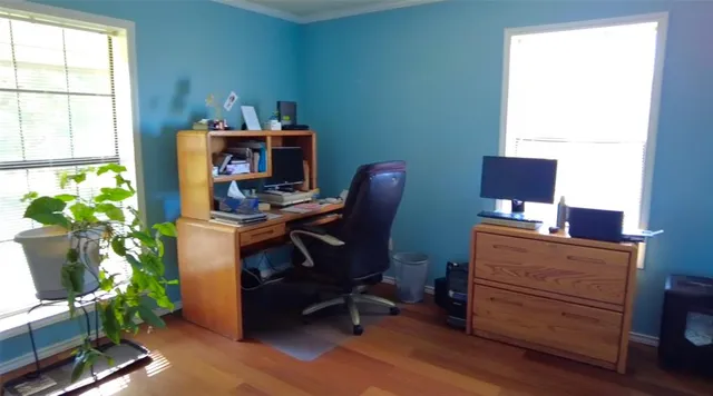 a view of a workspace with furniture and a window