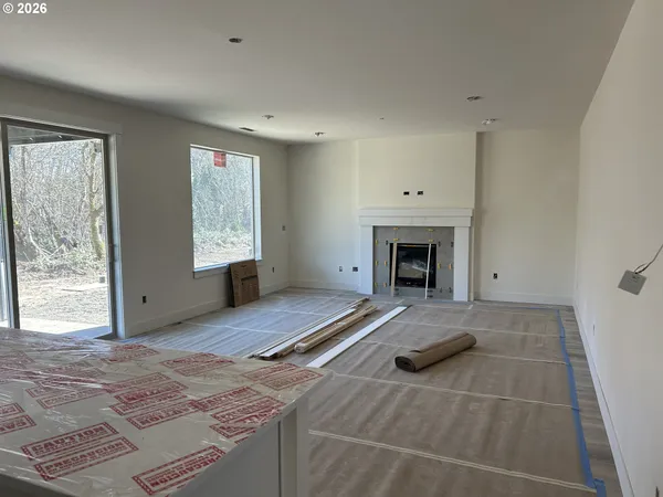 a view of an empty room with a fireplace and a window