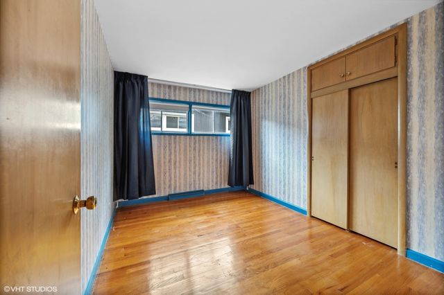 a view of a livingroom with wooden floor and a bathroom
