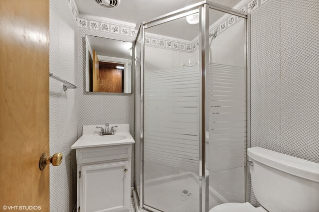 a bathroom with a shower a mirror and a sink