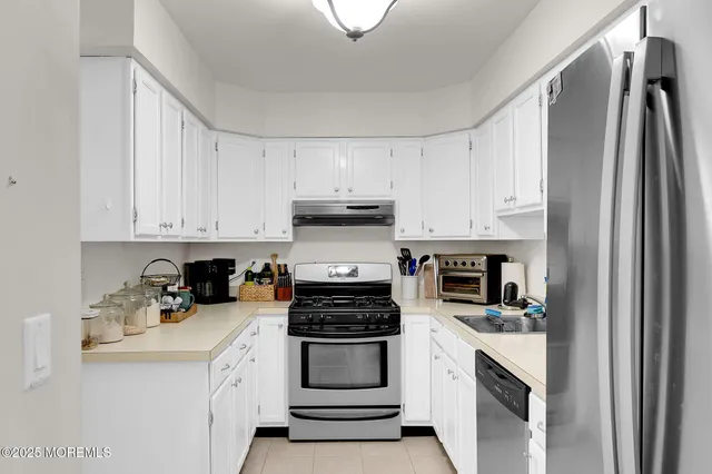 a kitchen with stainless steel appliances granite countertop a refrigerator and a stove