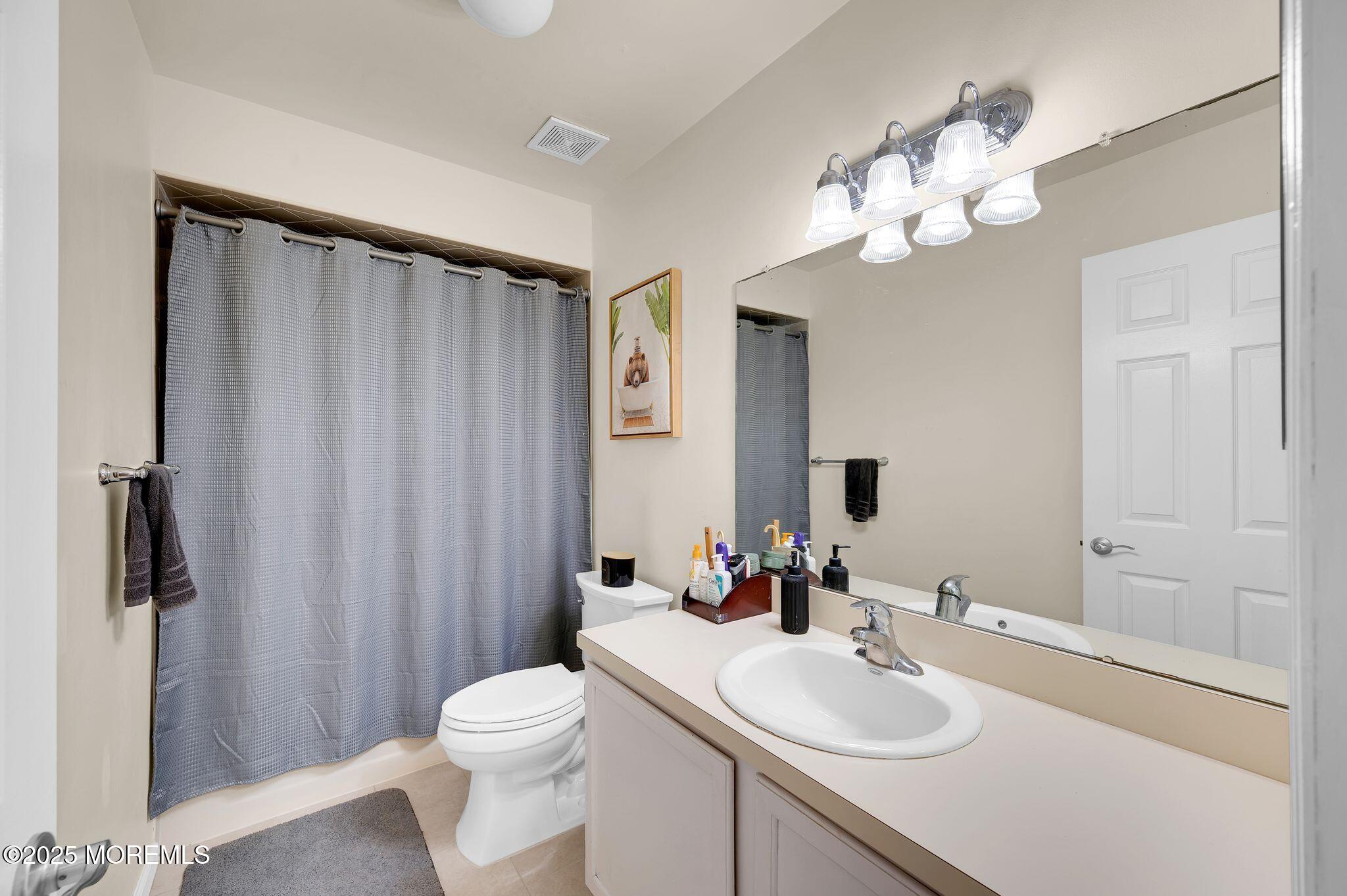 33 South Pointe Circle Tinton Falls, NJ 07753 - Photo 21 of 31 a bathroom with a sink a toilet and shower curtain