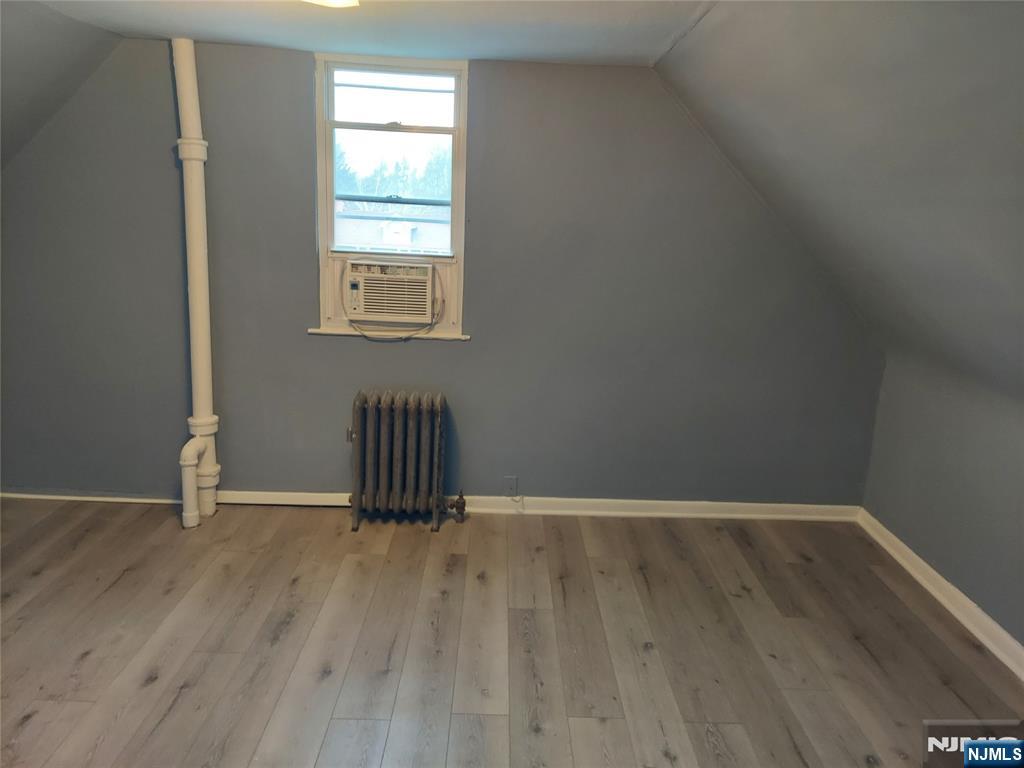 64 East Madison Avenue, Unit #2 Dumont, NJ 07628 - Photo 11 of 14 a view of an empty room with wooden floor and a window