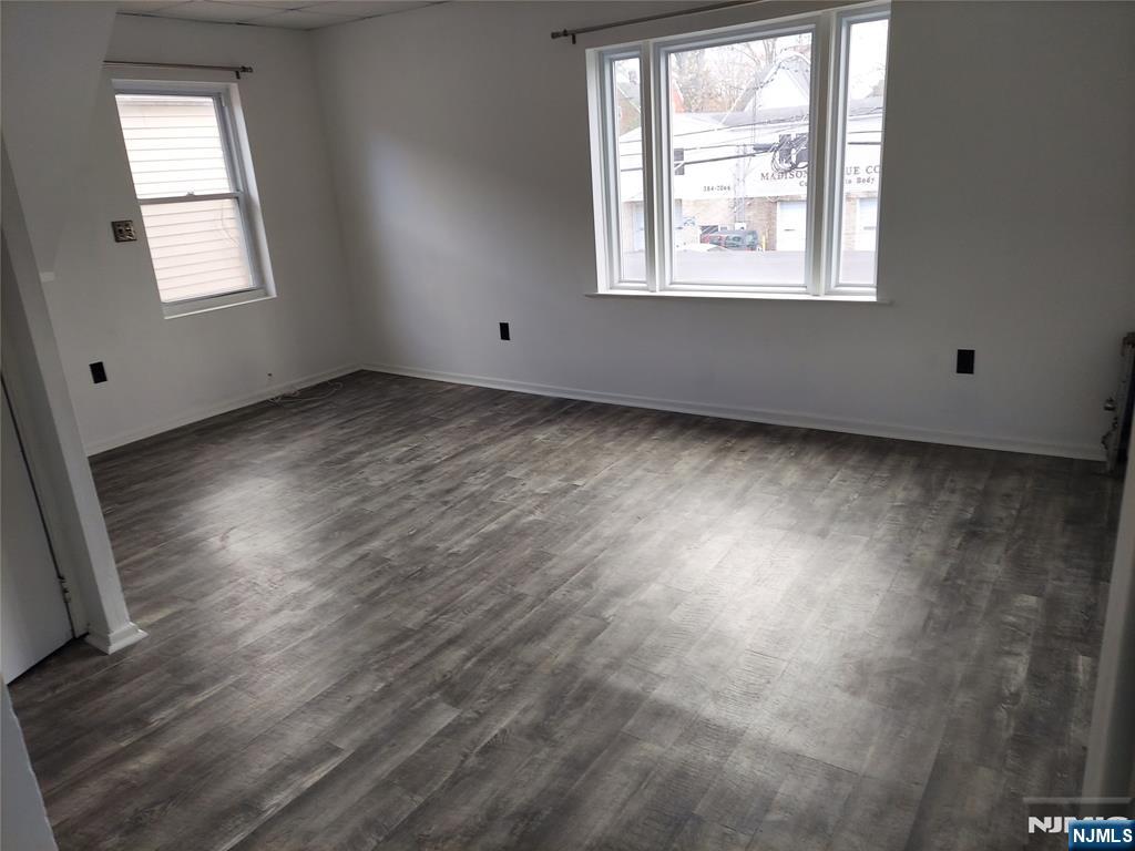 64 East Madison Avenue, Unit #2 Dumont, NJ 07628 - Photo 5 of 14 an empty room with wooden floor and windows