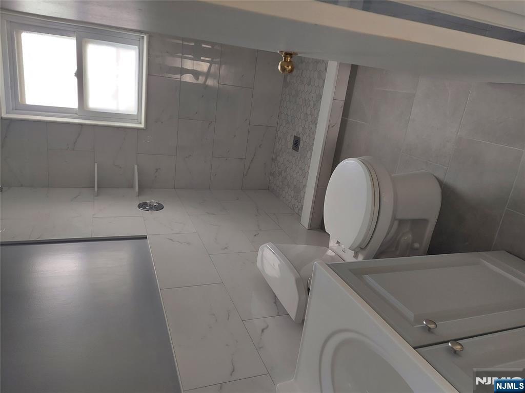 64 East Madison Avenue, Unit #2 Dumont, NJ 07628 - Photo 6 of 14 a white toilet sitting next to a bathroom sink