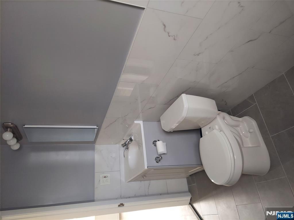 64 East Madison Avenue, Unit #2 Dumont, NJ 07628 - Photo 7 of 14 a white toilet sitting next to a bathroom sink