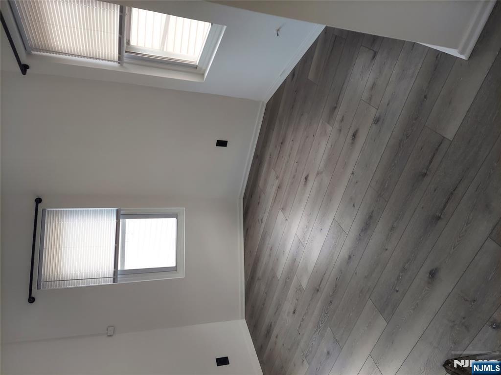 64 East Madison Avenue, Unit #2 Dumont, NJ 07628 - Photo 9 of 14 an empty room with wooden floor and windows