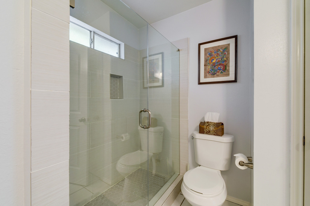 6002 Baton Rouge Drive Austin, TX 78727 - Photo 14 of 20 Glass-enclosed shower with white tiled walls and a built-in niche