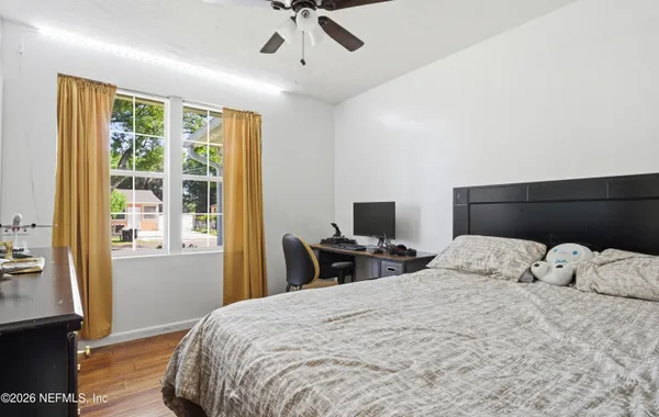 a bedroom with a bed and wooden floor