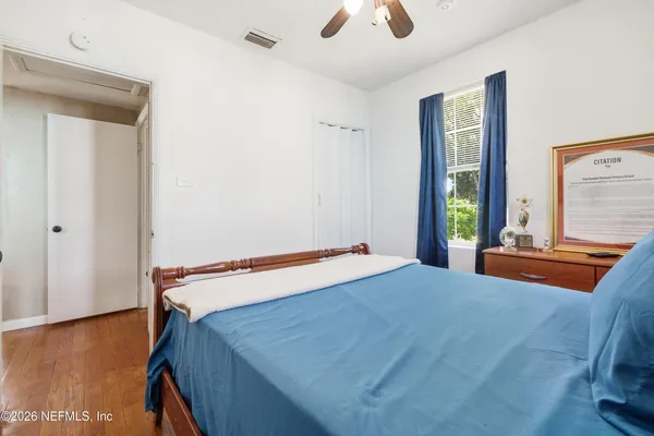a bedroom with a bed and large windows