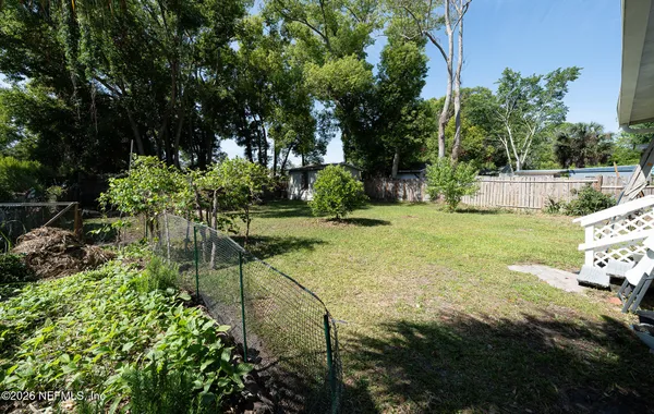 a view of a backyard with large trees