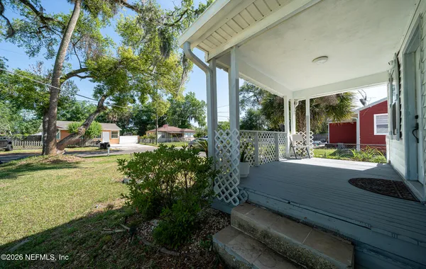 a view of a patio with table and chairs potted plants and large tree