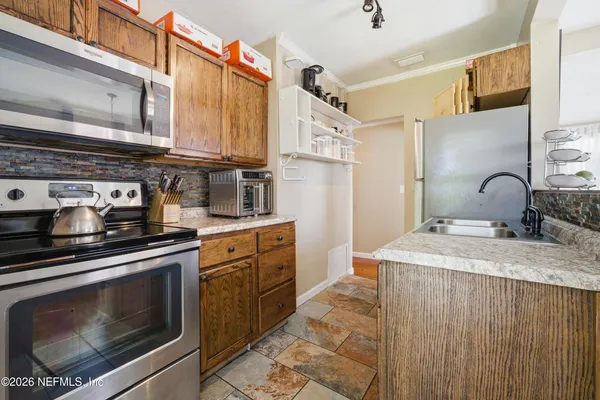a kitchen with stainless steel appliances granite countertop a stove a sink and a microwave