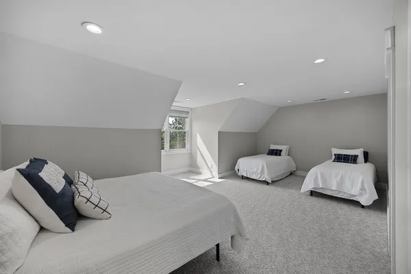 a bedroom with two bed and a lamp