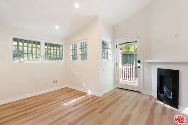 a view of empty room with wooden floor