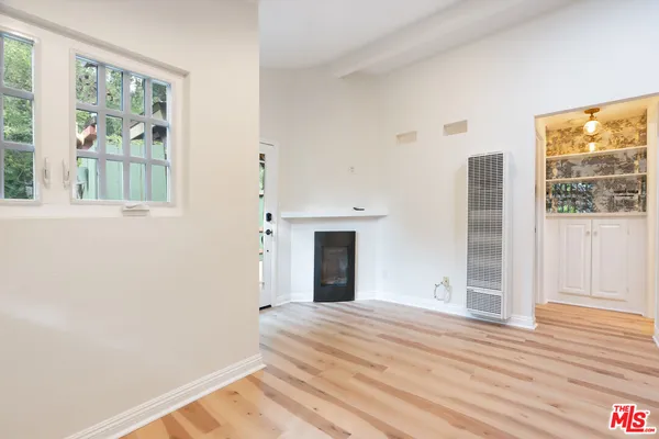 a view of backyard with large trees and wooden fence