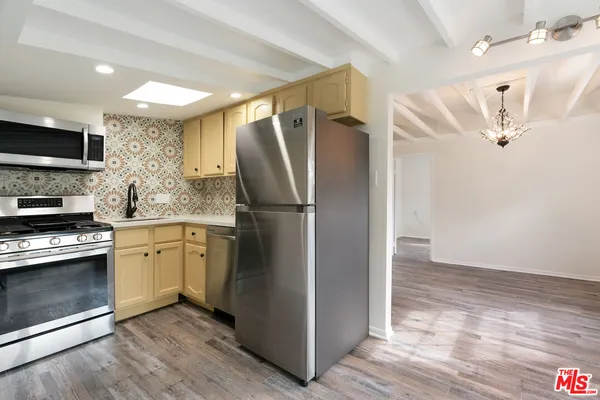 a view of a street with potted plants and large trees
