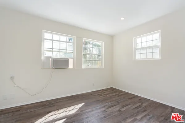 an empty room with wooden floor and a window
