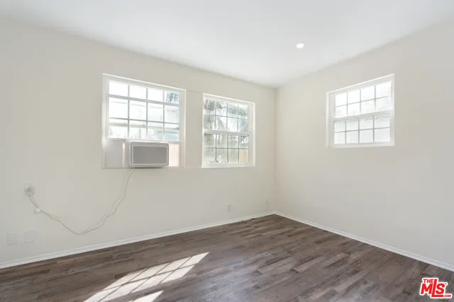 an empty room with wooden floor and a window