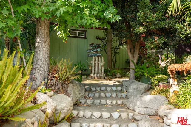 a living room with stainless steel appliances kitchen island granite countertop a dining table chairs refrigerator and microwave