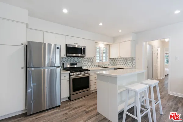 a kitchen with stainless steel appliances granite countertop a sink and a stove