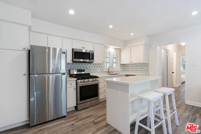 a kitchen with stainless steel appliances granite countertop a sink and a stove