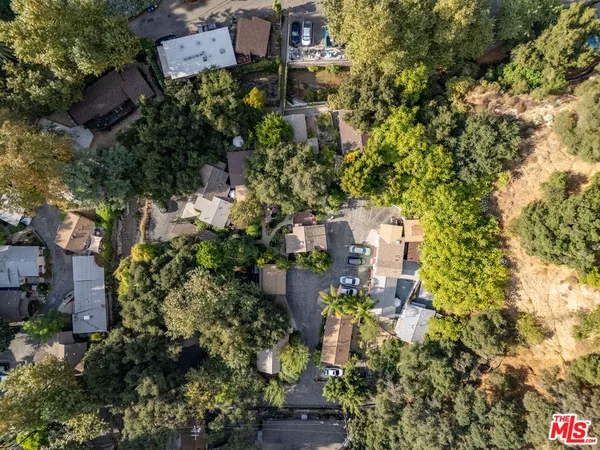 an aerial view of a residential apartment building with plants and large trees