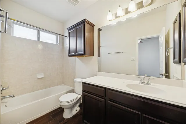 a bathroom with a sink a toilet a mirror and bathtub