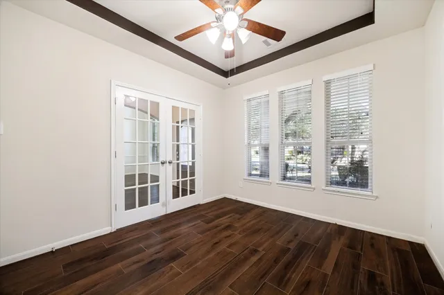 a view of an empty room with a window and wooden floor