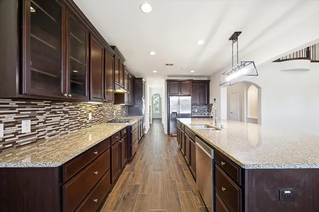 a large kitchen with granite countertop a sink and cabinets