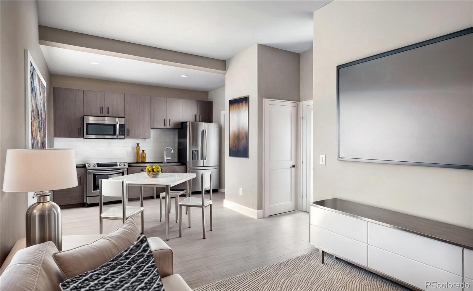 a living room with stainless steel appliances furniture a rug and a refrigerator