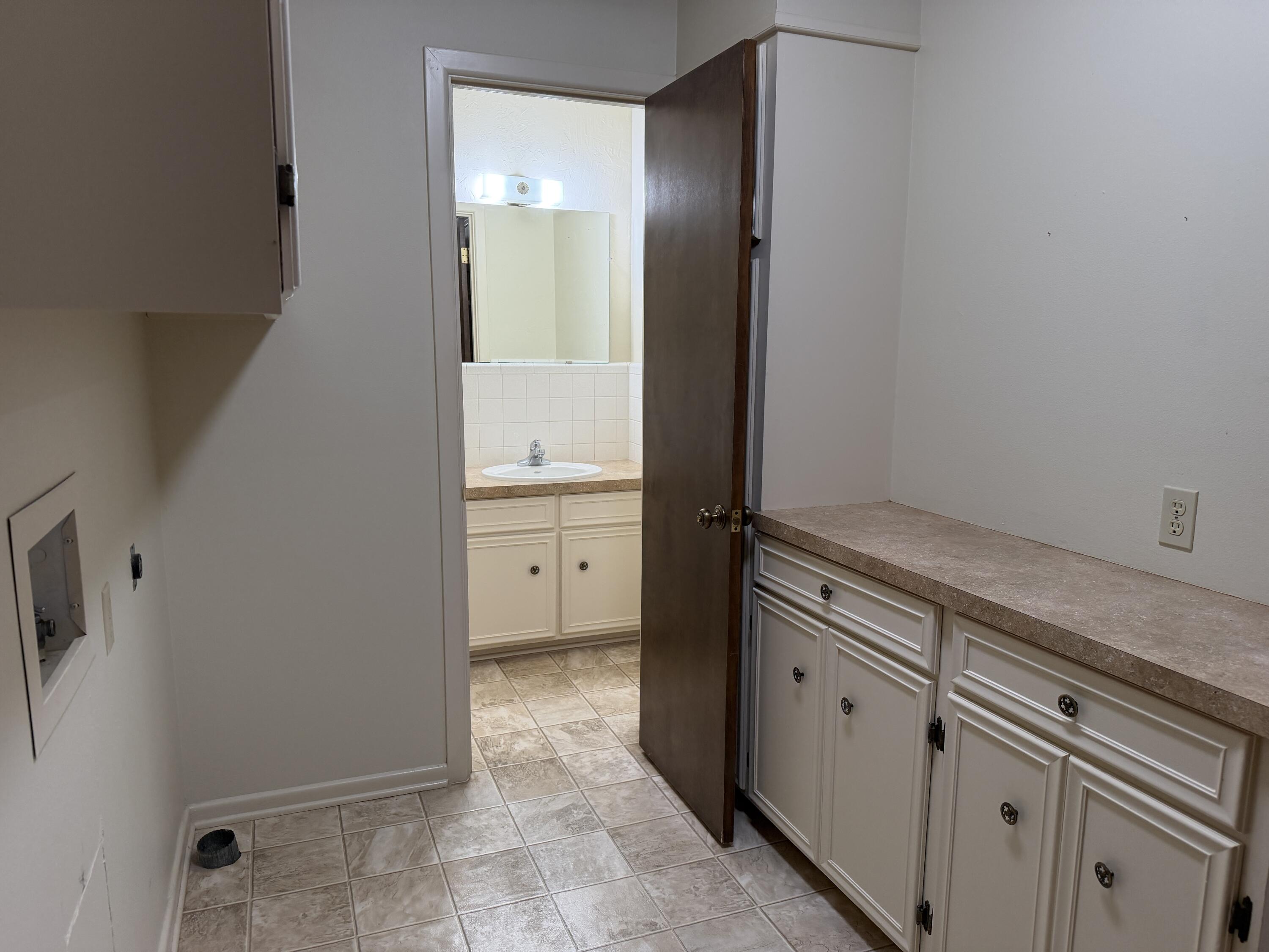 1603 South 8th Street Lamesa, TX 79331 - Photo 29 of 39 a spacious bathroom with a granite countertop sink and a mirror