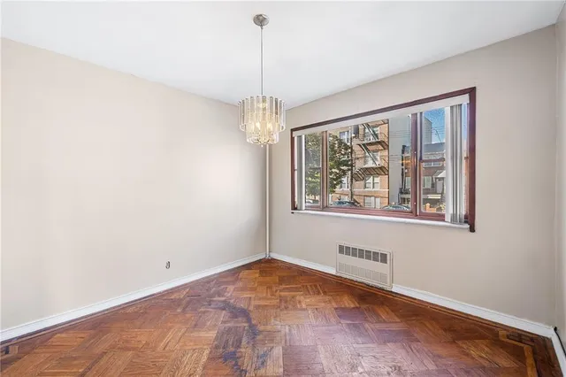 a view of empty room with wooden floor and ceiling fan