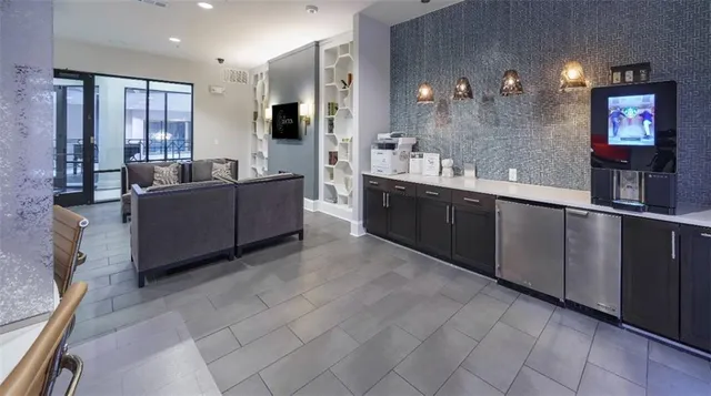 a large living room with stainless steel appliances granite countertop a sink and dishwasher a large mirror