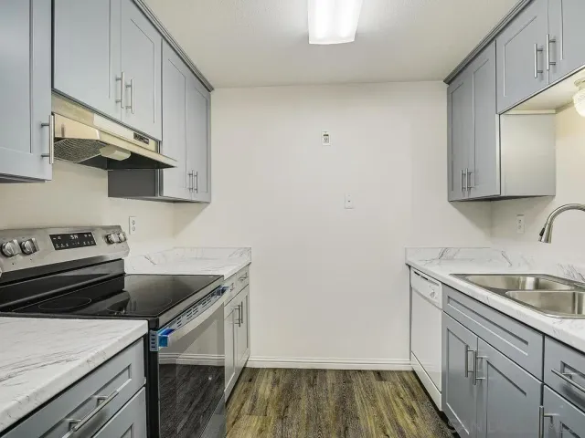 a kitchen with a sink stove and cabinets